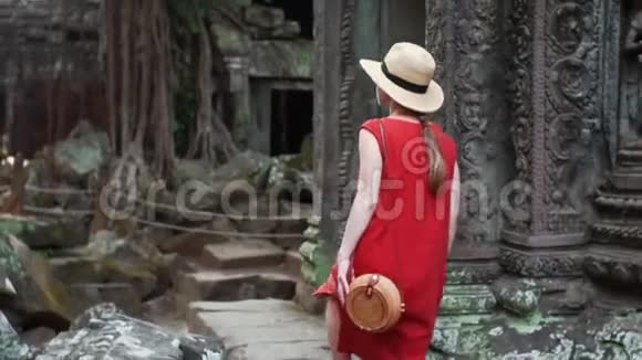 穿着红色衣服的白人妇女正在塔普罗姆废墟中行走视频的预览图