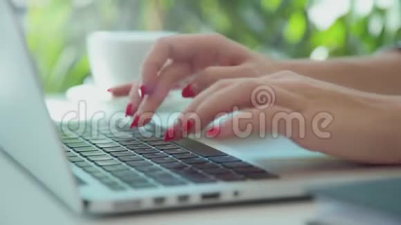 女性年轻的双手在笔记本电脑键盘上印有整齐的红色指甲印视频的预览图