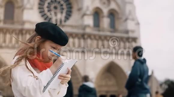 小可爱的贝雷帽和红领巾坐在巴黎圣母院附近在法国巴黎画素描视频的预览图