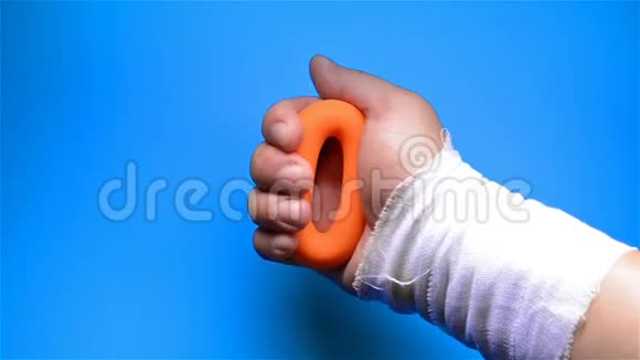 一只受伤的手通过挤压手握环进行康复训练视频的预览图