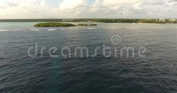 无人机在被绿松石水包围的天堂岛上射击有棕榈和珊瑚礁的岛屿视频的预览图