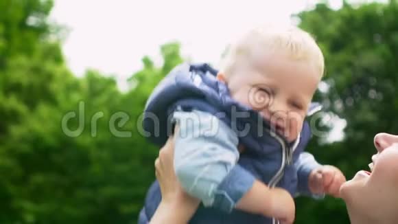 妈妈抱着她一岁的儿子亲吻公园视频的预览图
