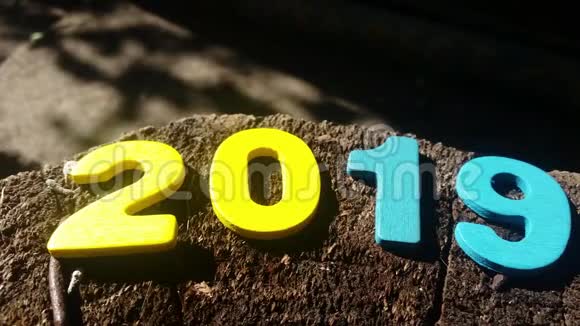 祝2019年新年快乐木制背景上的彩色图形视频的预览图
