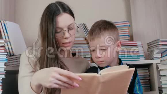 妈妈为坐在书中的儿子读了一本书妈妈戴着眼镜视频的预览图
