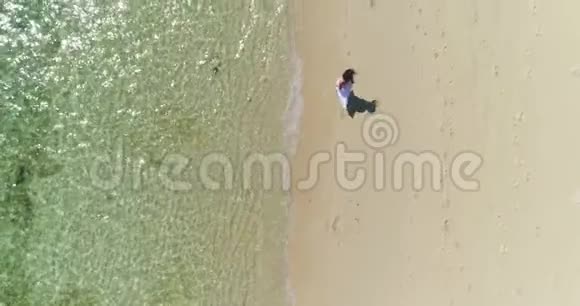 空中穿着白色连衣裙的布鲁内特女孩正沿着海边奔跑视频的预览图