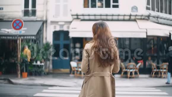 法国巴黎的年轻美女过马路后景穿斗篷的时髦女性走在街上视频的预览图