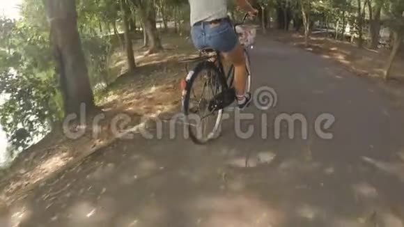 年轻的嬉皮士女子骑着老式自行车在城市公园骑自行车高清Gopro慢速运动视频的预览图
