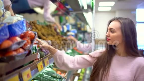 超市里的女人选择超市里的西红柿选择蔬菜视频的预览图