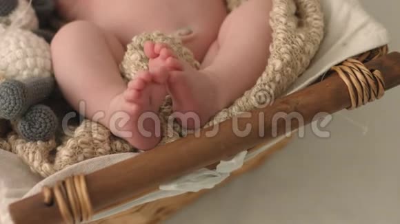 母亲抚摸着刚出生睡在摇篮里的婴儿赤裸的脚跟视频的预览图