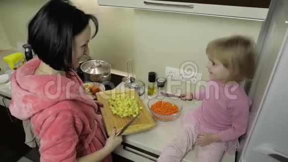 可爱的小女孩和她妈妈一起做饭小女儿和妈妈在一起视频的预览图