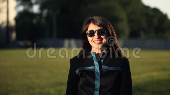 布鲁内特年轻女性戴着太阳镜微笑的肖像视频的预览图