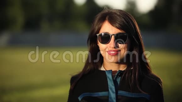Brunette年轻女性戴着太阳镜微笑的画像视频的预览图
