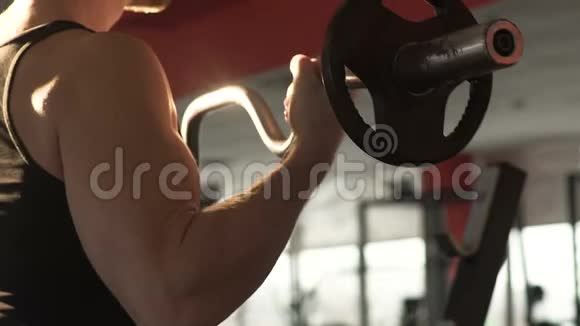 肌肉男在健身房用卷发棒做仰卧起坐锻炼强壮的肌肉视频的预览图