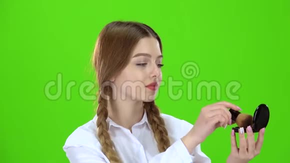 女学生用刷子把鼻子涂成粉末绿色屏幕视频的预览图