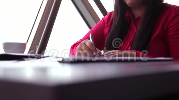 特写镜头年轻的女商人处理办公室文件并接电话视频的预览图