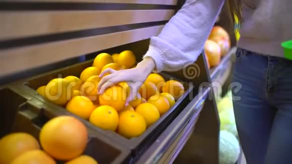 在一家超市的水果和蔬菜过道上一位女士在杂货店挑选柠檬视频的预览图