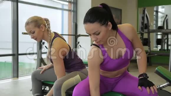两个女运动员正在现代健身房做集中卷发视频的预览图