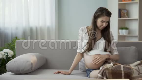 年轻的孕妇躺下来休息抱着泰迪熊未来的孩子视频的预览图
