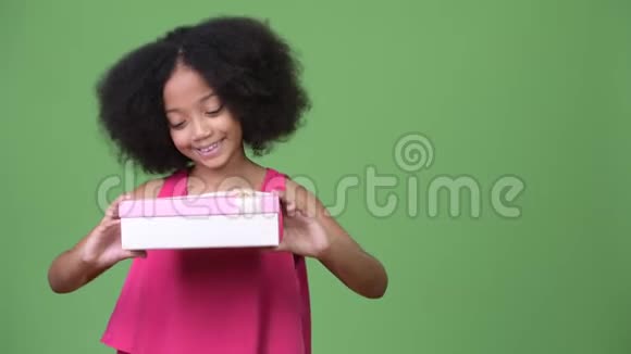 年轻可爱的非洲女孩非洲头发拿着礼品盒视频的预览图