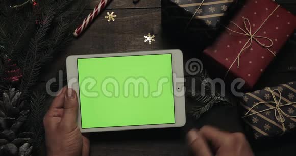 圣诞老人的手滚动敲击缩放页面上的白色平板电脑与绿色屏幕其他人视频的预览图