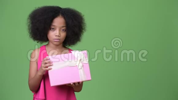 年轻可爱的非洲女孩非洲头发拿着礼品盒视频的预览图