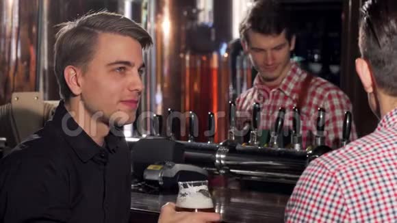 有魅力的年轻人和他的朋友一起喝啤酒视频的预览图