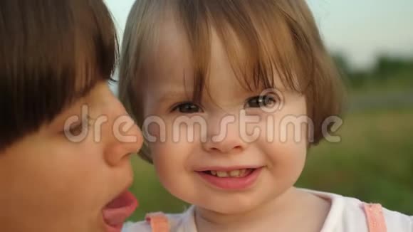 小孩子抱着妹妹微笑用相机露出手指夏天一家人在公园散步动作很慢视频的预览图