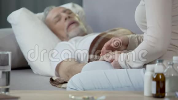 女儿关心生病的父亲躺在床上退休和疾病健康视频的预览图