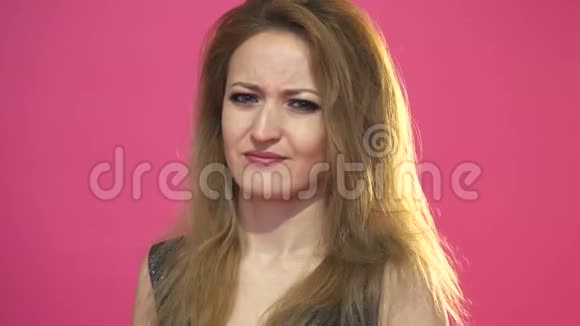 冷静的年轻美丽的女人棕色的头发说不摇头不敢相信粉红色的背景视频的预览图