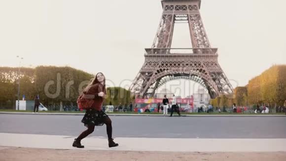 年轻时尚的女性在法国巴黎埃菲尔铁塔附近奔跑和跳跃青少年很高兴看到这一著名的景象视频的预览图