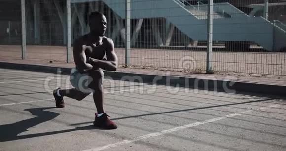 非裔美国人运动员在现代体育场附近做侧蹲攻击运动锻炼健身健康视频的预览图
