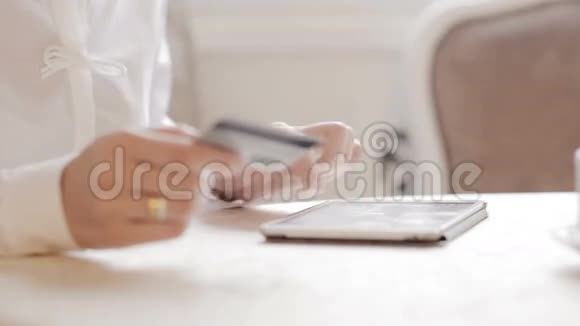 女人用平板电脑在线购物透过玻璃视频的预览图