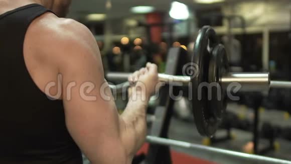肌肉男在健身房里用卷发棒做仰卧起坐积极锻炼健身视频的预览图