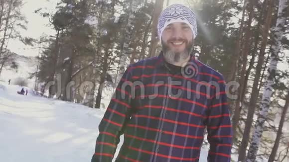 冬天森林里一个长胡子微笑的男人看镜头的肖像视频的预览图