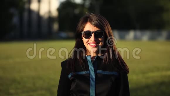 布鲁内特年轻女性戴着太阳镜微笑的肖像视频的预览图