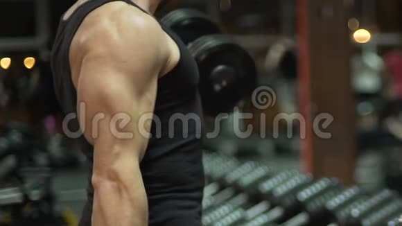 男子做举升手拿沉重的哑铃锻炼手臂肌肉视频的预览图