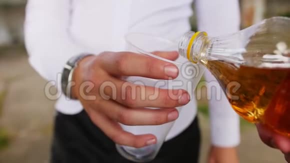 把柠檬水从瓶子里倒入塑料玻璃里近距离射击视频的预览图