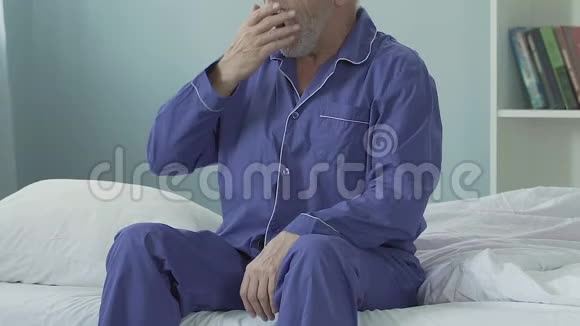 老年男性起床后坐在床沿伸展身体面带微笑视频的预览图