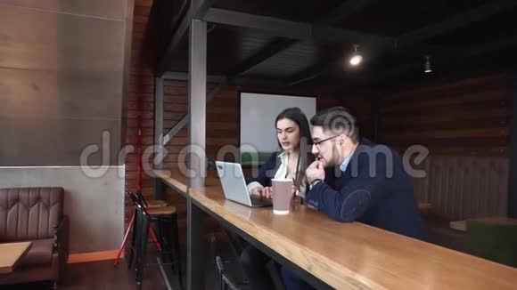 两位同事讨论在一家咖啡馆里工作的问题咖啡馆里有一台笔记本电脑和咖啡坐在办公桌前视频的预览图