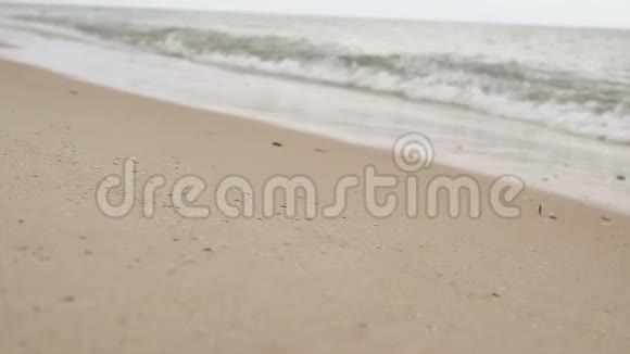 女孩沿着沙滩和海浪奔跑慢镜头拍摄视频的预览图