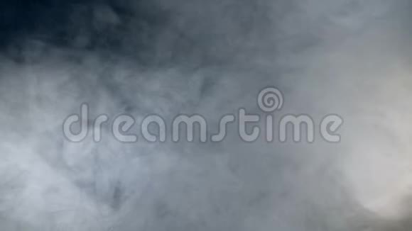 厚厚的烟雾在黑暗中流动雾烟云隔在黑色背景上视频的预览图