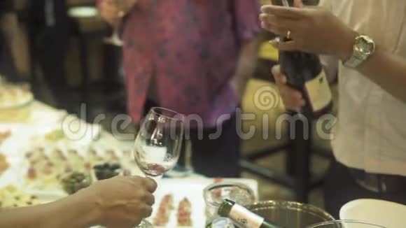 服务员在宴会上把红酒倒入玻璃杯中在宴会上把红酒倒入酒杯里的人视频的预览图
