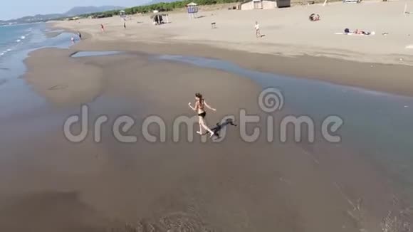 无人机从四面八方移走了一个沿着海滩奔跑的女孩视频的预览图