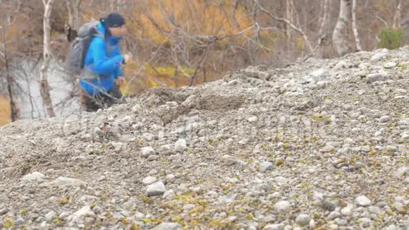 一个人独自在一个美丽的公园里旅行他爬上小山带着背包还带着特别的棍子视频的预览图