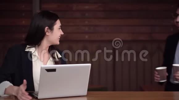 两位同事开始在笔记本电脑前用咖啡讨论案件视频的预览图