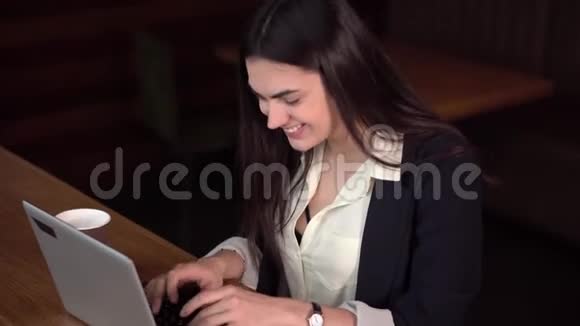 布鲁内特女孩喜欢在笔记本电脑上聊天看着忧郁在咖啡馆喝咖啡视频的预览图