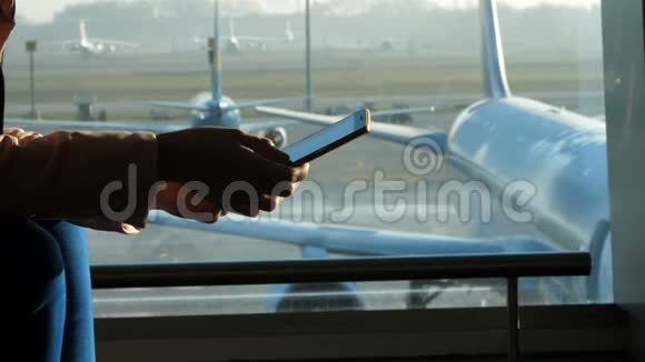 特写镜头在机场在候机室在一扇窗户的背景下俯瞰飞机和飞机视频的预览图