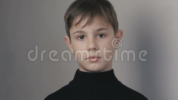 穿着黑色毛衣看镜头的10岁小男孩的肖像视频的预览图