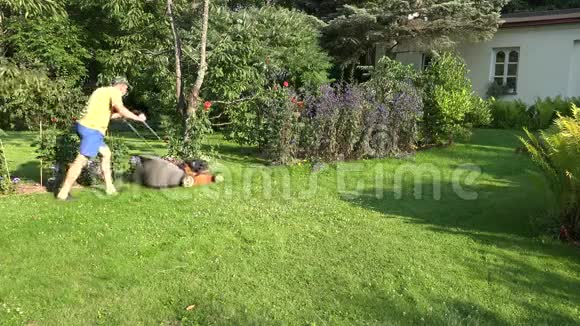 人们在家附近的绿色花园里用割草机工作4K视频的预览图