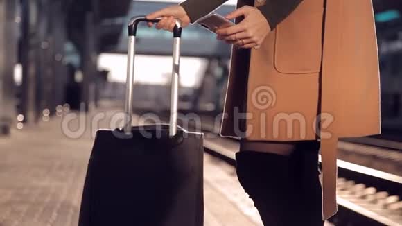 女脚提着行李站在站台等车视频的预览图